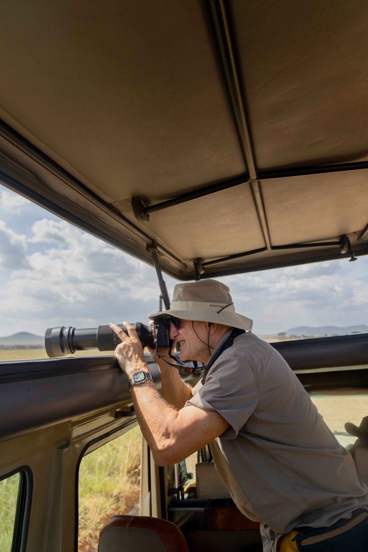 Guest photographing wildlife from a private safari vehicle