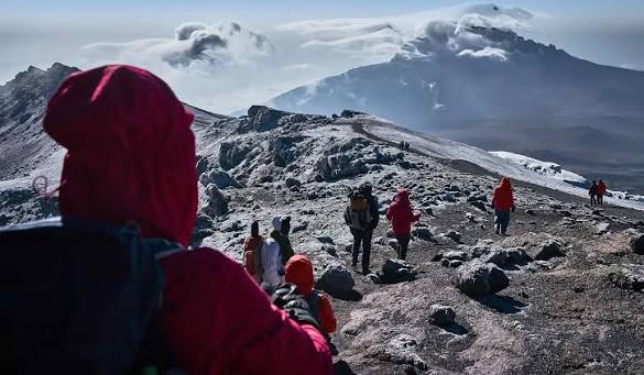 Trekkers crossing rocky high-altitude terrain on Mount Kilimanjaro