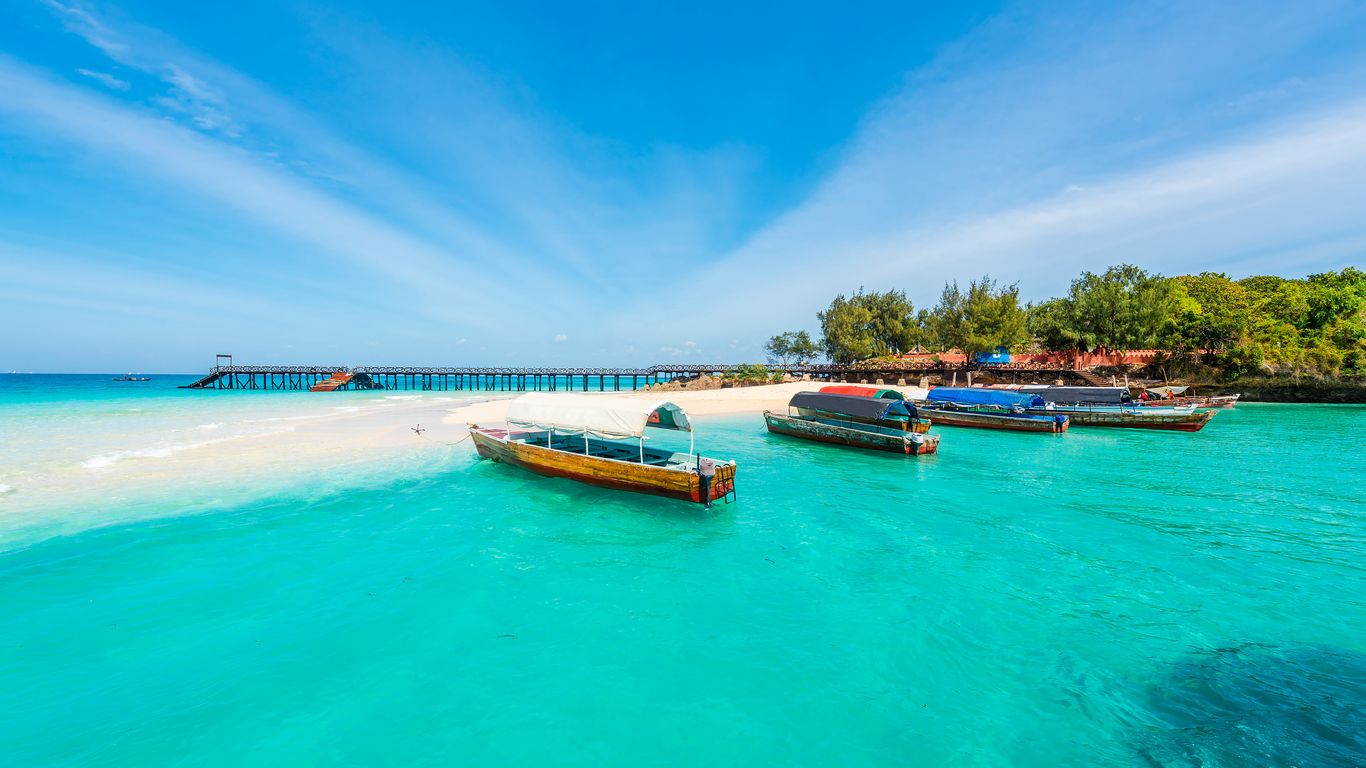 Wooden boats floating in clear turquoise water off Zanzibar