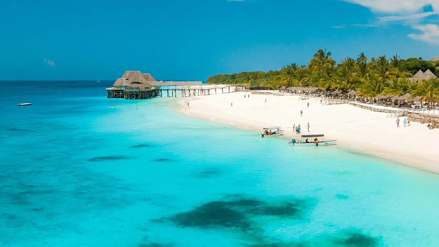 White sand beach, palms and clear blue water on the Zanzibar coast